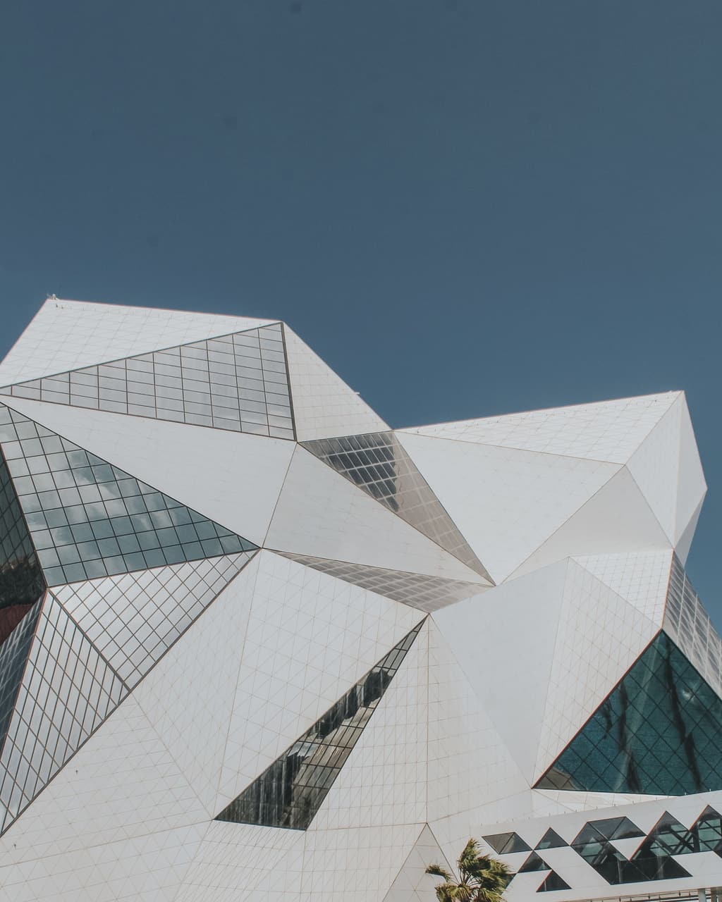 Faceted white and glass building against a clear sky in Abu Dhabi