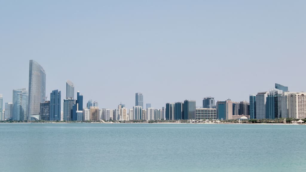 Abu Dhabi skyline across calm water on a clear morning
