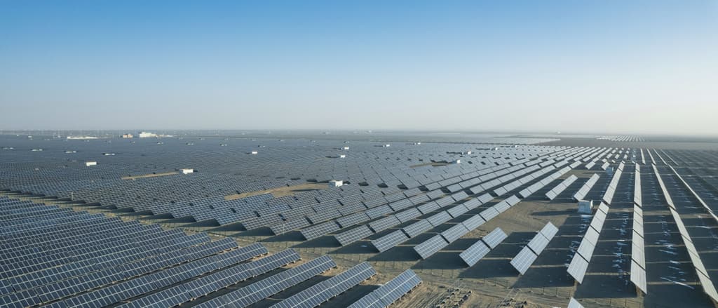 Rows of solar panels stretching to the horizon in a desert