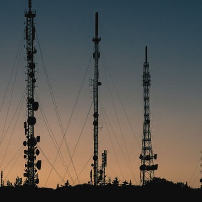 Telecommunication masts silhouetted against the dusk sky